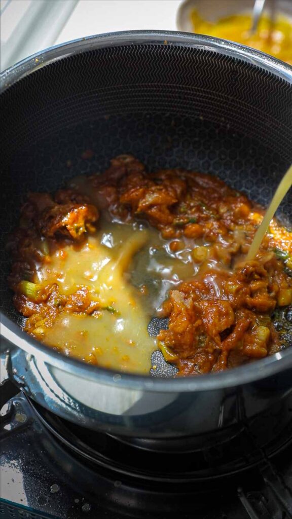 adding vegetable broth to pot